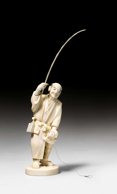 OKIMONO OF A FISHERMAN.Japan, Meiji period, H 28 cm. Ivory. The cheerful figure, standing on a plinth, has just caught the fish that he holds in his left hand. Signed. Fishing line snapped.