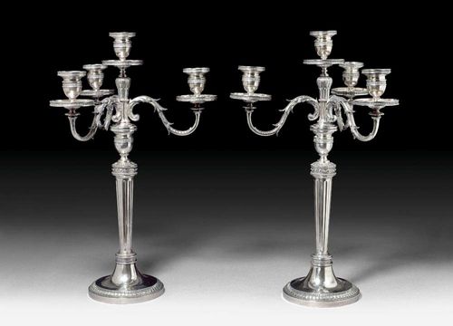 PAIR OF GIRANDOLES. Lucerne, end of the 19th century.Maker's mark Bossard. Vaulted round foot with a palm frieze surround.  Fluted shaft. Node with pearl frieze and leaf rosette. 1 central and 3 curved light arms. Vase-shaped nozzles with a surround of laurel leaves and drip plates. H 52 cm. Total weight 4040 g.