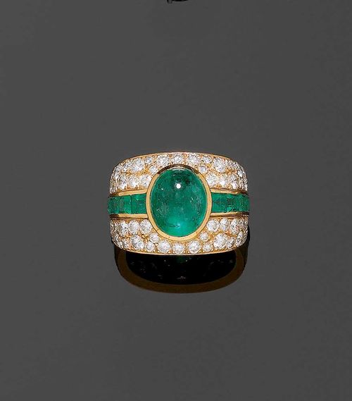 EMERALD AND BRILLIANT-CUT DIAMOND RING. Yellow gold 750. Attractive, broad band ring, the top set with 1 oval emerald cabochon of ca. 4.50 ct, flanked by 10 carré-cut emeralds totalling ca. 1.50 ct and completely set with 36 brilliant-cut diamonds totalling ca. 1.40 ct. Size ca. 59.