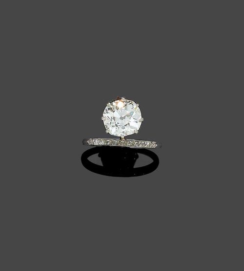 DIAMOND RING, ca. 1915. Platinum. Very stylish Solitaire model, set with 1 old mine cut diamond of ca. 2.80 ct, ca. M-N/ SI2, chipped on the edge, mounted on the side of the fine bar which is decorated with a row of 11 diamond roses. Size 53. With copy of estimate Bucherer.