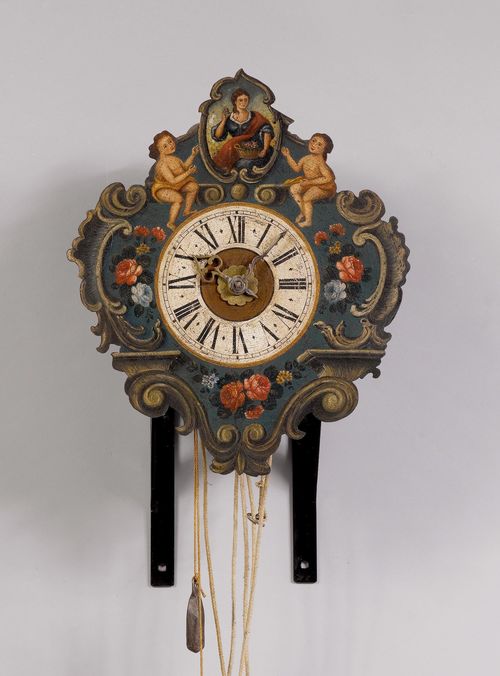 IRON CLOCK WITH ALARM,Baroque, probably Switzerland or Germany, 18th century. Enclosed case, the dial painted with rocailles, flowers, putti and a woman with a basket of flowers. Movement with anchor escapement and 2 striking mechanisms, striking the 3/4-hour on 2 bells. Alarm on bell. Repetition on demand. H 43 cm. Painting redone. Case, in part later.