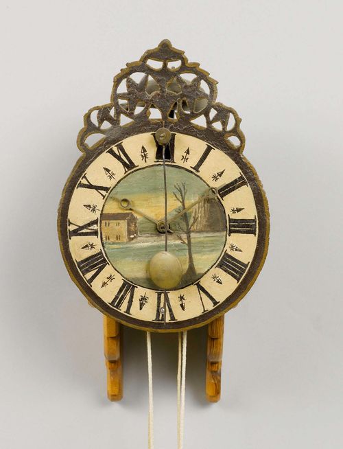 IRON CLOCK, Switzerland or Southern Germany, Baroque,  17th century. Brass and iron movement in open-worked case. Verge escapement striking the half hours on bell. Front pendulum. Large metal dial with later painted decoration. Mounted on later wooden bracket. H 30 cm.