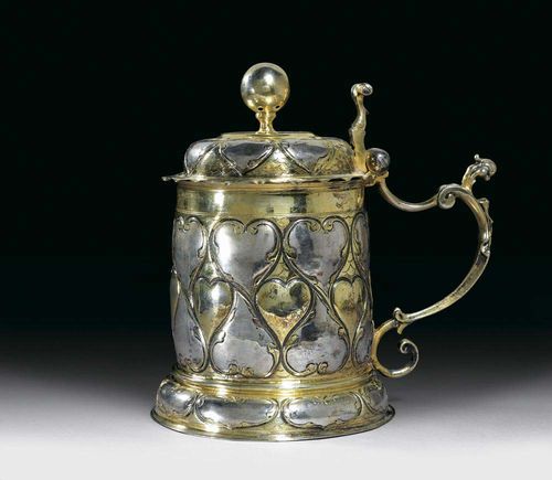TANKARD AND COVER. Augsburg, circa 1700. Maker's mark struck out. Parcel-gilt, chased, cast and embossed. With cast shaped handle.  H 23 cm, 1060 g.