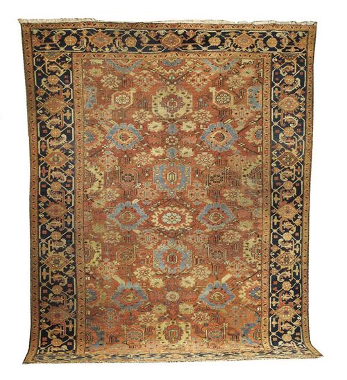 HERIZ antique. Rust red ground patterned with stylised flowers in blue and yellow, with dark border. Some wear.  370x285 cm.