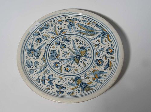 TAZZA, Spain. Painted in blue, heightened in ochre yellow and green. D 27cm, H 4.5cm. Hairline cracks and small repairs to the rim. Provenance: private collection, South Germany.