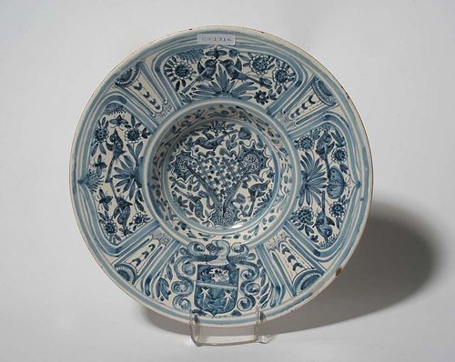 BOWL WITH BLUE PAINTED DECORATION, Spain. Densely painted in the style of Ligurian ceramics. With fantasy coat of arms. D 28.5cm. Small chip to rim. Provenance: private collection, South Germany