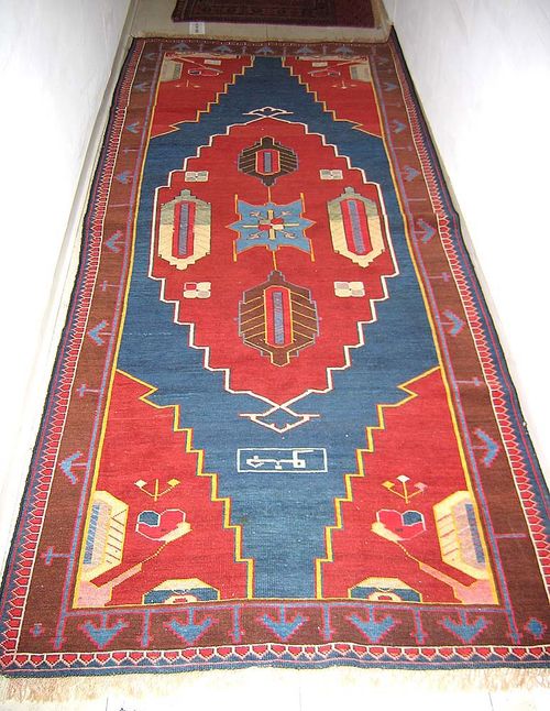 ARMENIAN. Rust red central medallion on blue ground and red corner motifs. Geometric patterned with stylised floral motifs. Good condition. 245x104 cm.