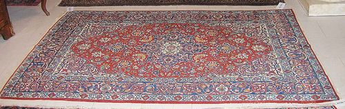 ISFAHAN old. Red ground with blue central medallion. With typical patterning of trailing flowers and palmettes in attractive natural colours. Blue border. Good condition. 138x215 cm.