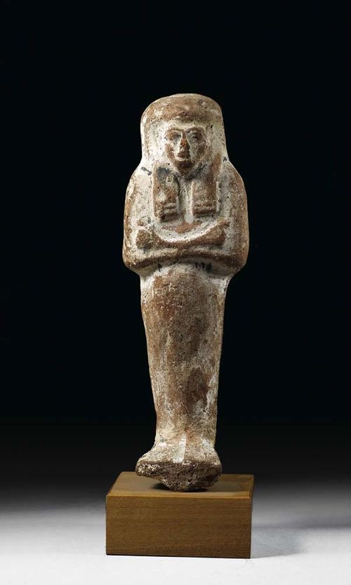 USCHEPTI, Egypt. Red clay with remains of white and black painting. On wooden plinth. H 18.5 cm.