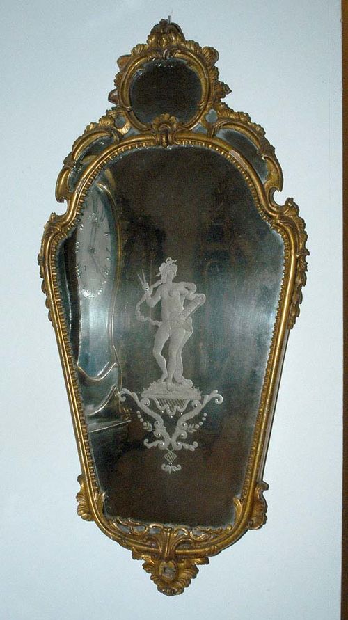 CARVED GILTWOOD MIRROR, Baroque, Italy circa 1760. With finely engraved mirror plate with depiction of Urania. H 90 cm, W 45 cm. Provenance: private collection, West Switzerland.