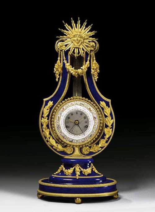 LYRE CLOCK, Louis XVI, the case presumed to be from the stock held by the widow of G. Courieult (Gabriel Courieult, died 1786) the enamel painting by J. COTEAU (Jean Coteau, Geneva 1740-1801 Paris), the silver coloured dial attributed to A.L. BREGUET (Abraham Louis Breguet, Neuchâtel 1747-1823 Paris) and inscribed verso B592, Paris circa 1788/90. Blue Sèvres porcelain known as "beau bleu". The lyre shaped case with Apollo bearing the enamel ring. The enamel ring with precisely painted star signs set in oval medallions, the months and the date, the dial with 4 finely pierced hands. Fine brass movement striking the 1/2 hours on bell. Exceptionally fine matte and polished gilt bronze mounts and applications. 27x15x59 cm. Provenance: formerly collection of Vincent Mulne, South Africa.