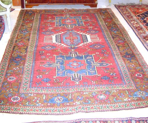 KARADJA antique. Red central field with three medallions, geometric patterned in white and blue, brown border, slight wear, 210x145 cm.