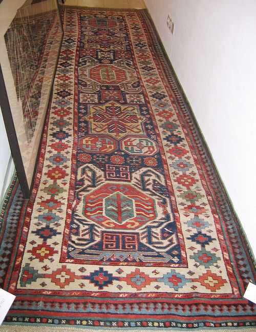 CAUCASIAN runner, old. Dark blue central field with five medallions, geometrically patterned, white border, one side border missing, slight wear, 380x110 cm.