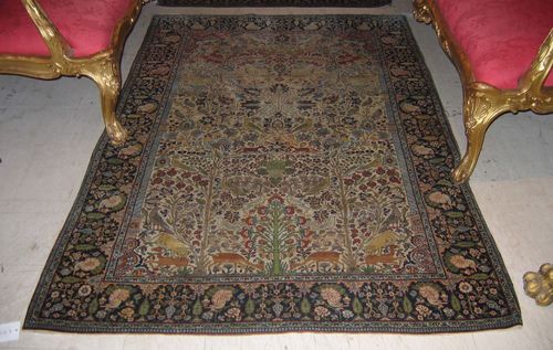 KIRMAN LAVER old. White ground, opulently decorated in attractive pastel colours with depictions of plants and animals, black border, slight wear, 210x135 cm.