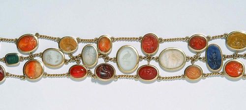 GEM BRACELET. Yellow gold 750. Fancy bracelet with 23 oval gem stones of various sizes and colours, including carnelians, citrines, lapis-lazulis, chalcedony, jasper et. al., with mythological representations and animal motifs, connected to one another by means of small chain links. L 19 cm.