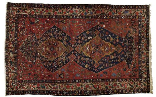 BACHTIAR antique. Red ground with two red and blue medallions, geometrically patterned throughout with stylized plant motifs in harmonious colours, beige, blue border with flower garlands, good condition, 510x315 cm.