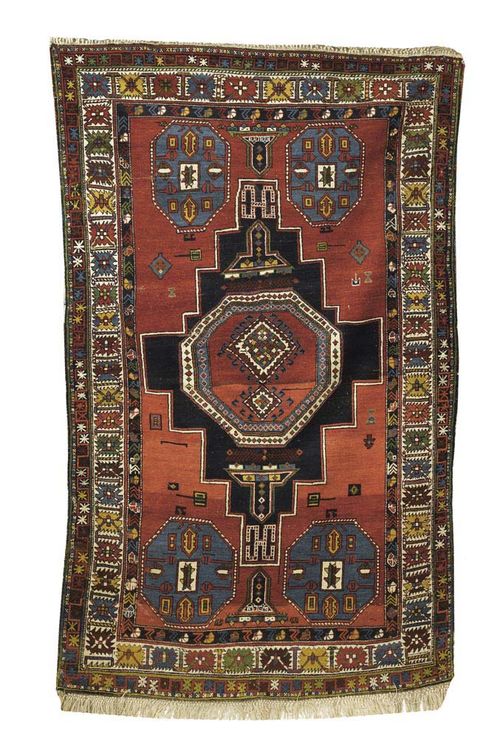 SHIRVAN antique. Rust red ground with stepped black-red central medallion and blue octagons. Brightly coloured triple stepped border. Some wear. 220x135 cm.