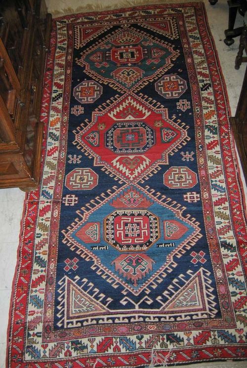 DERBEND old. Blue ground with 3 large hooked medallions in green and red, geometric patterned throughout, with wine glass border. Slight wear. 138x313 cm.