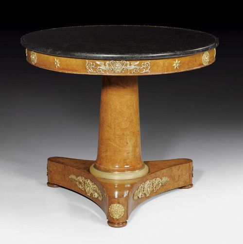 ROUND SALON TABLE,Empire/Restauration, stamped J.J. WERNER (Jean-Jacques Werner, Geneva 1791-1853 Paris), Paris circa 1815/20. Burl ash. The black/grey speckled marble top with columnar shaft and three-sided base. With rich gilt bronze mounts and applications. D 78 cm, H 78 cm. Provenance: - R. Redding, Zurich. - Private collection, Germany.
