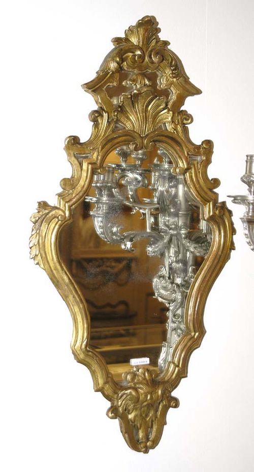 CARVED GILTWOOD MIRROR, late Baroque, Italy, 18th/19th century. With masks and shells, the cartouche-shaped frame with old mirror plate. H 75, W 41 cm.