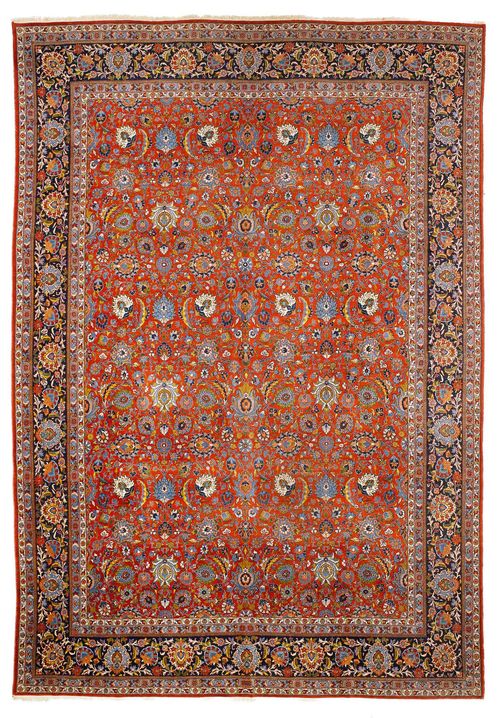KESHAN antique. The red ground is patterned with trailing flowers and palmettes in harmonious colours. With a black border. Slightly worn, 325x447 cm.