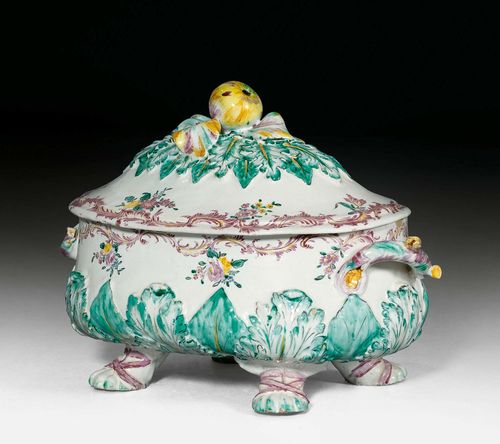 LARGE FAIENCE TUREEN AND COVER,Italy, circa 1750. Oval baluster shape modeled with leaves heightened in green. Painted with a circumferential manganese red rocaille border at the edge with hanging polychrome floral sprays. Without mark. D 38 cm. Hairline crack in the base and cover.