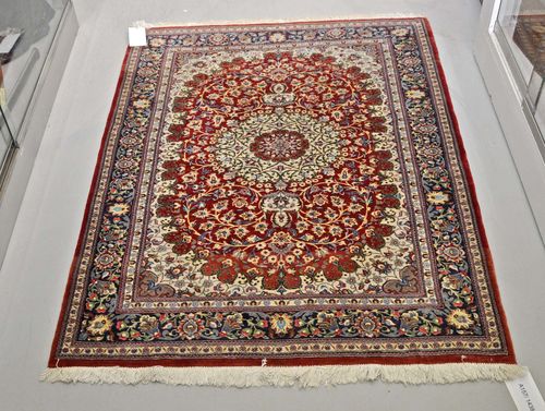GHOM.Red ground with a central medallion, patterned with trailing flowers, blue edging, 110x140 cm.
