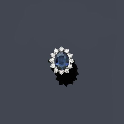 SAPPHIRE AND DIAMOND RING. White gold 750. Elegant ring, the top set with 1 oval sapphire of ca. 7.75 ct, set within a classic border of 12 brilliant-cut diamonds weighing ca. 1.87 ct. Size ca. 54.5. Matches the previous lot.