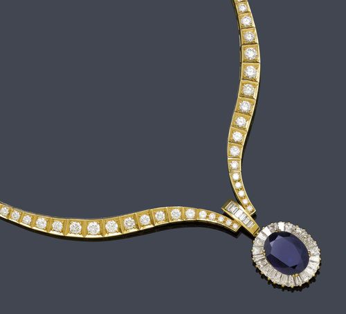 SAPPHIRE AND DIAMOND NECKLACE. Yellow gold 750. Fancy Rivière necklace of 93 graduated brilliant-cut diamonds weighing ca. 12.00 ct, the "V"-shaped front part additionally decorated with 6 baguette-cut diamonds weighing ca. 0.30 ct, and a removable pendant set with 1 oval sapphire of ca. 10.00 ct set within a border of 24 trapeze-cut diamonds weighing ca. 3.50 ct. L ca. 41 cm.