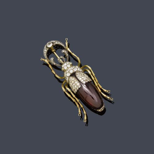 GARNET, DIAMOND AND GOLD BROOCH, St. Petersburg, ca. 1900. Silver over yellow gold, 56 zolotniki. Original brooch designed as a stag beetle, the head and pincers set throughout with numerous old European-cut diamonds, the body of an oval garnet cabochon of ca. 30 x 10 mm. The eyes set with 2 small emeralds. Ca. 5.5 x 2 cm. With case by Wartski, London.