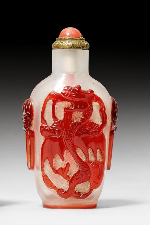 A TRANSPARENT GLASS SNUFFBOTTLE WITH RED GLASS OVERLAY DECORATION OF A DRAGON.