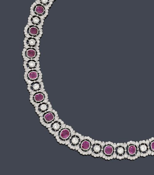 RUBY AND DIAMOND NECKLACE. White gold 585, 61g. Classic-elegant, open-worked necklace set with 28 oval rubies weighing ca. 20.00 ct and 28 brilliant-cut diamonds weighing ca. 3.30 ct, additionally set throughout with 476 smaller brilliant-cut diamonds  weighing ca. 9.60 ct.  L ca. 42 cm. With case and Jeweller's certificate by Gruschow, Berlin.