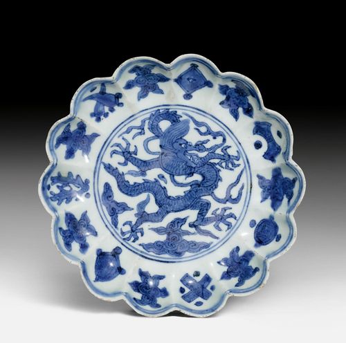A VERY RARE BLUE AND WHITE LOBED SAUCER DISH PAINTED WITH AN IMPERIAL DRAGON AND DAOIST SYMBOLS.