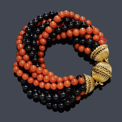 CORAL AND ONYX BRACELET. Clasp in yellow gold 750. Casual-decorative bracelet with 4 strands of red coral beads of ca. 6 mm Ø, and 4 onyx beads. The clasp of 1 ribbed gold bead between 2 matching half-spherical attaches. L ca. 22.5 cm.