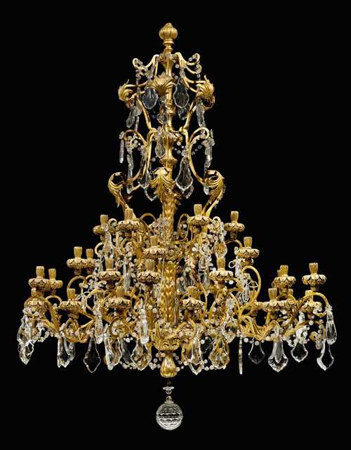 IMPORTANT CHANDELIER, Louis XV, Genoa, 18th/19th century. Richly carved and gilt wood with rich, partly cut-glass and crystal hangings. With 36 branches. D 120 cm, H 150 cm. Provenance: - Formerly part of the collections of the Palazzo Borromeo on Isola Bella, Italy. - From a European private collection.