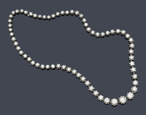 DIAMOND NECKLACE, ca. 1960. White gold 750, 42g. Elegant, classic Rivière necklace, set with 66 graduated brilliant-cut diamonds in rosette-shaped settings. Total diamond weight ca. 19.80 ct. L ca. 44.5 cm.