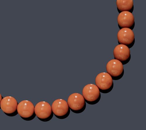 CORAL NECKLACE. White gold 750. Decorative necklace of 40 fine, salmon-pink coral beads of ca. 12 mm Ø, clasp integrated into a coral, flanked by 2 diamond-set rondelles weighing ca. 0.40 ct. L ca. 48.5 cm.