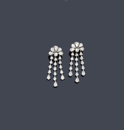 DIAMOND EAR PENDANTS, ca. 1950. White gold ca. 660. Classic-elegant, fine ear clips with studs, each of 1 stylized flower motif set with 1 brilliant-cut diamond and 5 drop-cut diamonds, weighing ca. 3.10 ct in total. The lower part each of 3 flexible lines of drop-cut diamonds with a total of 32 drop-cut diamonds weighing ca. 3.40 ct. L ca. 5 cm.