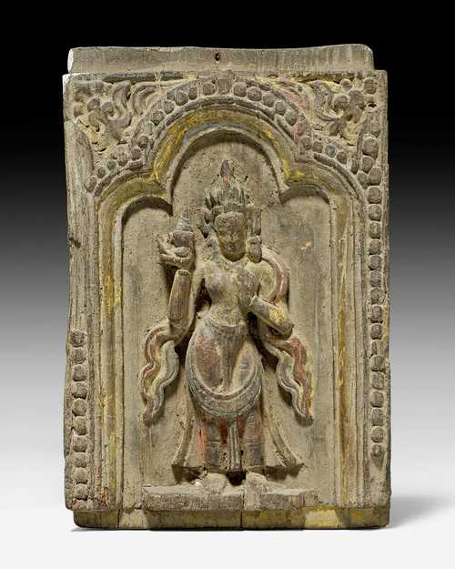 A SMALL WOODEN PANEL CARVED WITH A STANDING GODDESS.