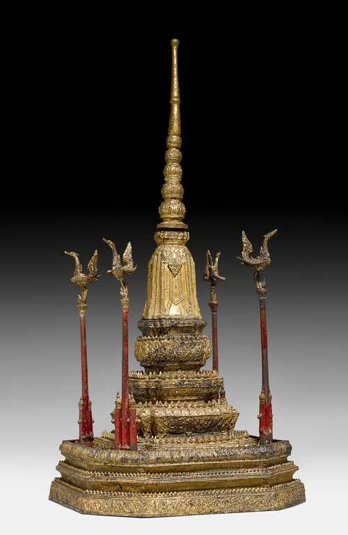 A THREE PART LACQUER GILT BRONZE STUPA SURROUNDED WITH FOUR HAMSA BIRDS ON PILLARS.