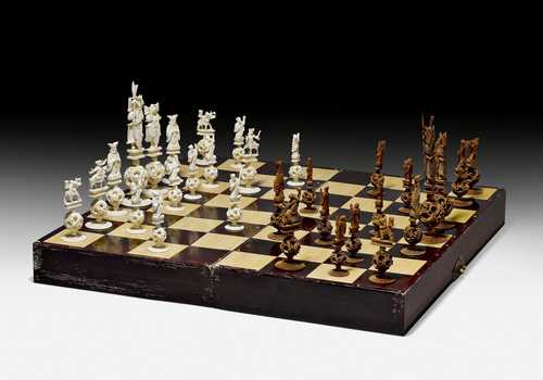 A CARVED IVORY CHESS SET, EACH FIGURE SURMOUNTING A MOVEABLE PUZZLE BALL.