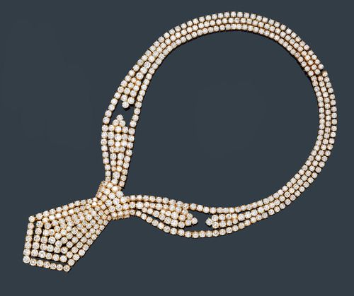 DIAMOND NECKLACE, M. GERARD, France, ca. 1970. Yellow gold 750. Fancy, very decorative, flexible necklace designed as a stylised tie, set throughout with ca. 411 brilliant-cut diamonds weighing ca. 60.00 ct. Signed M. Gérard, No. 2603. L ca. 38 cm. Matches the previous lot. With case.