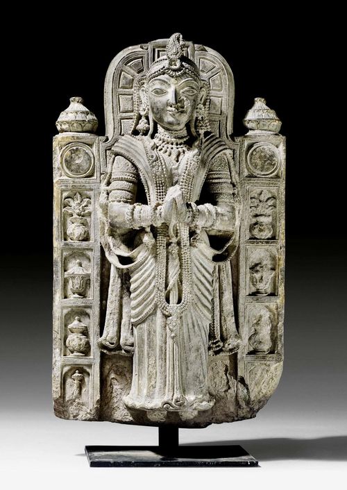A GREY STONE STELE OF A FEMALE ATTENDANT. India, Rajasthan, circa 17th c. Height 47 cm.