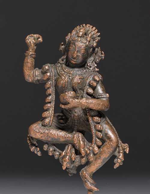 A COPPER FIGURE OF A DANCING DAKINI. Nepal, 13th c. H 10 cm (without mounting pin). Fire damage.