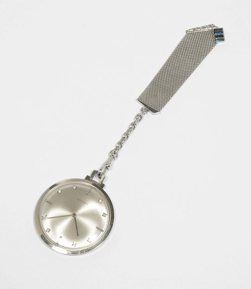 DIAMOND TUXEDO WATCH WITH PENDANT, JUVENIA, 1970s. White gold 750, 47g. Flat case No. 715119 with silver-coloured dial, diamond indices and silver-coloured hands. Small lever movement with flat spring, Cal. 604. D 41 mm. Matching watch pendant decorated with 4 baguette-cut sapphires and 7 small single-cut diamonds, L ca. 11 cm.