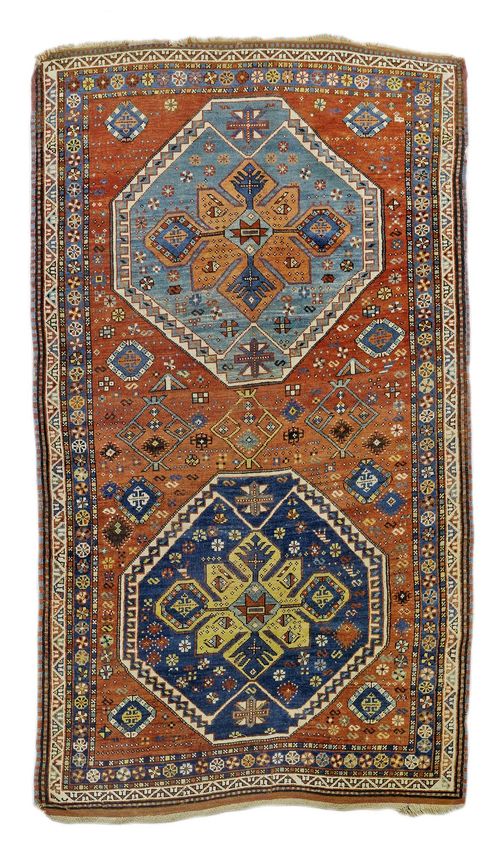 CAUCASIAN antique.Rust coloured central field with two octagonal medallions, geometrically patterned, narrow edging, 140x230 cm.
