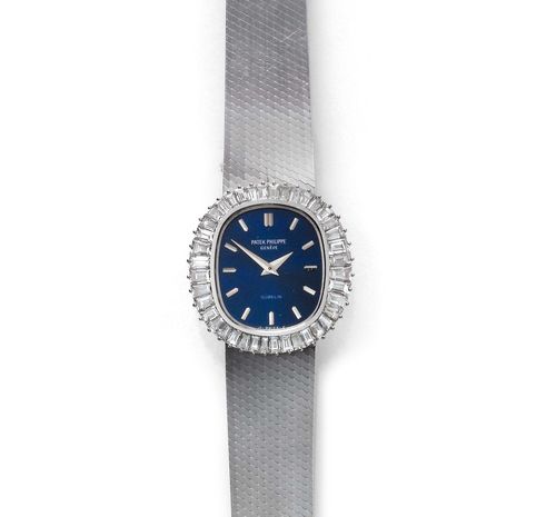 DIAMOND LADY'S WRISTWATCH, PATEK PHILIPPE, 1970s. White gold 750. Ref. 4138/1. Oval case No. 2714972, with diamond lunette weighing ca. 1.50 ct. Blue dial with silver-coloured indices and hands, signed. Hand winder, movement No. 1390674, Cal. 16.250. Fine, matte-finished original gold band, L ca. 17 cm. D 22 x 24 mm.