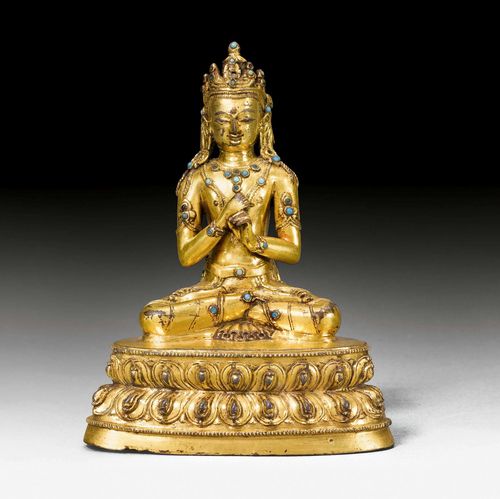 A FINE GILT COPPER FIGURE OF VAIROCANA WITH GEMSTONES AND GLASS INLAYS. Tibet, 16th c. Height 14.5 cm. Sealed.