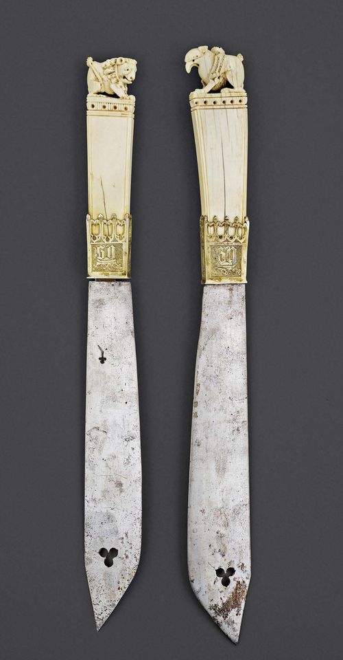 HUNTING CUTLERY,Gothic, probably Germany, 15th century. Ivory and silver-gilt. Comprising 2 knives. The silver mount with crowned BS monogram. The iron blade with trefoil punch mark as well as same-shaped perforation. Leather scabbard. L 44 cm. One grip probably shortened in length.