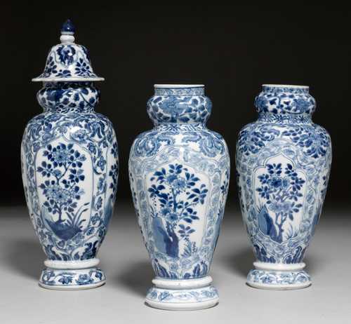 THREE BLUE-AND-WHITE VASES WITH FLORAL CARTOUCHES ON FLOWERED GROUNDS.
